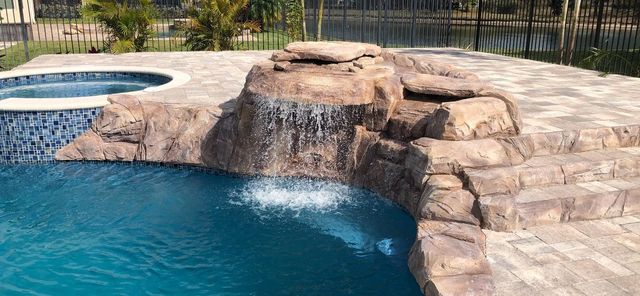 Completed custom pool with a natural rock waterfall feature